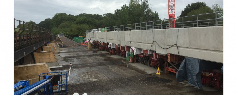Prefabricated deck span ready to be lifted into place after demolition of existing bridge