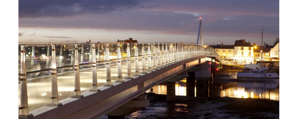 A dusk view showing the gentle arch of the bridge