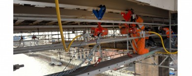 Contractors hanging hydraulic hoists from the bottom flanges of the rail bearers