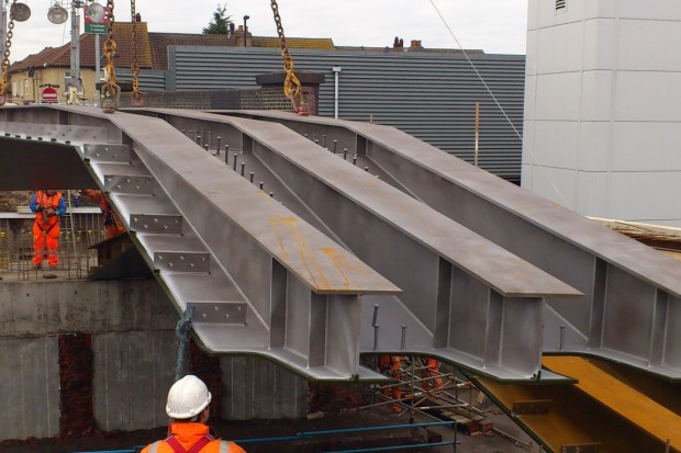 Streatham Common Station with contractors lowering the tripple 'I' beam arch into place